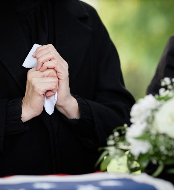 Close up of woman holding handkerchief and crying at outdoor funeral ceremony, copy space